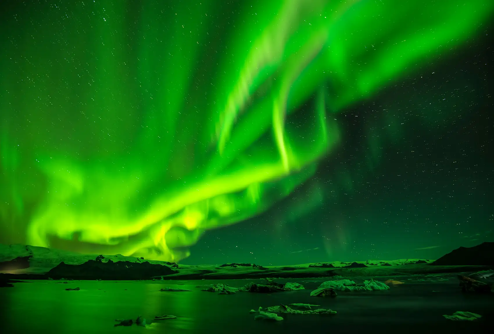 Una aurora boreal verde sobre un cielo despejado en Islandia