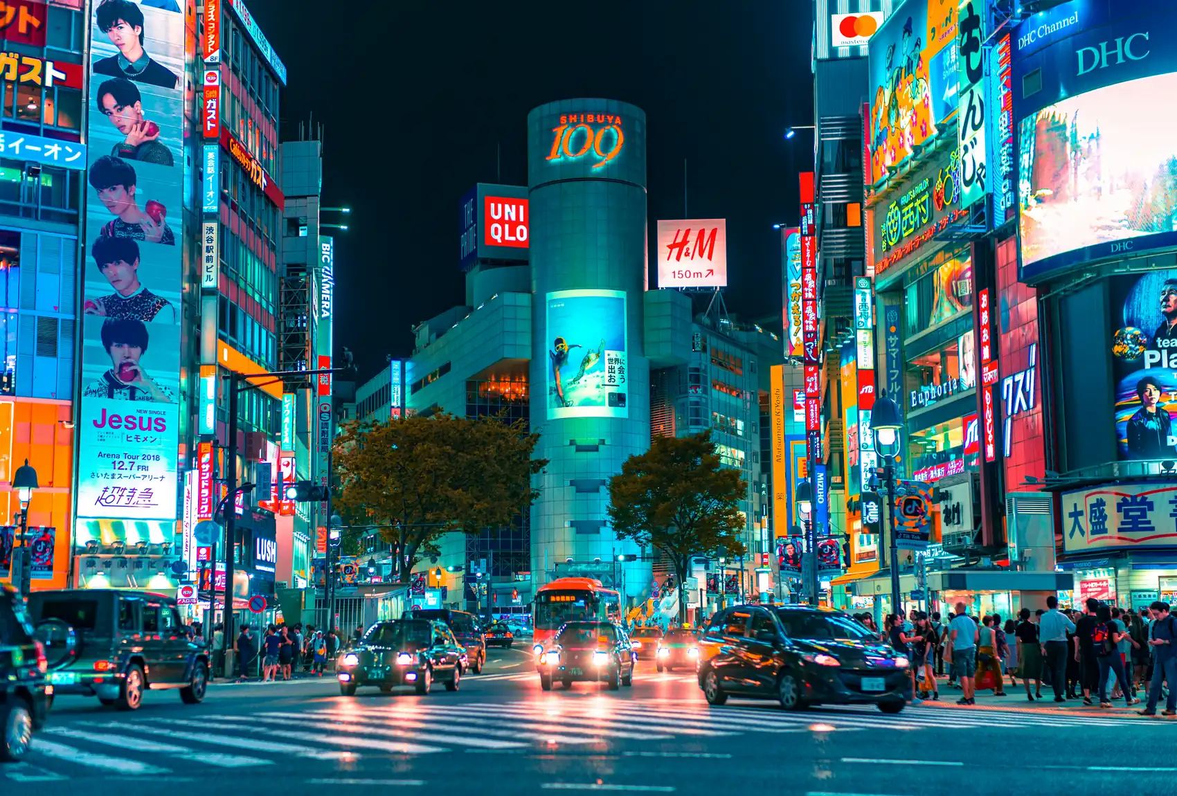 El cruce de Shibuya de noche, con los avisos de neón encendidos y la torre Shibuya 109 al fondo