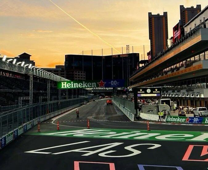 La recta de meta del circuito del Strip al atardecer, con el arco Heineken y la parrilla pintada en el asfalto